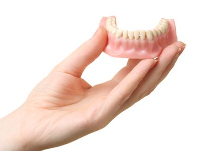 person holding a bottom set of dentures