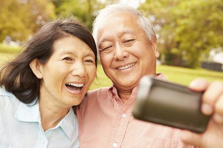 man with dentures taking pictures with his wife