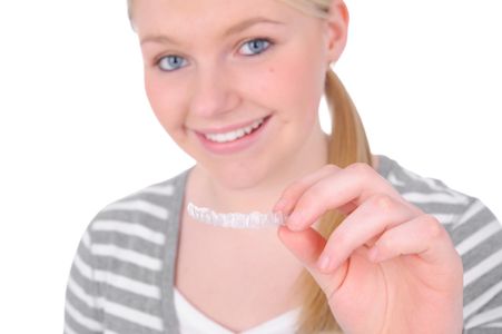 patient holding up her SureSmile clear aligners
